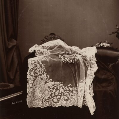 An image of a wedding veil draped over a stool showing its intricate and fine lines.